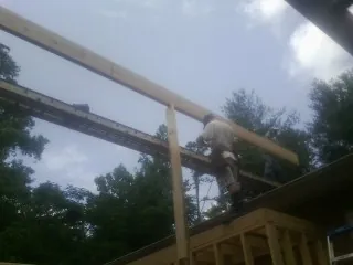 Carpenter setting a ridge beam over a new addition frame — Ice Dam Removal by Roofing Brothers in Stoddard