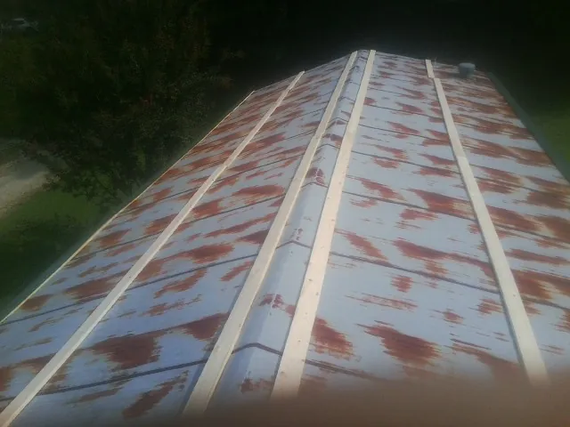 Rusted metal roof panels with new wood purlins before replacement — Storm Damage Roof Repair in Stoddard by Roofing Brothers