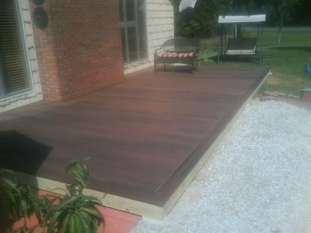 Freshly stained wood deck built against a brick home in Stoddard